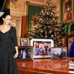 ملکہ الزبتھ ایک میز کے پیچھے بیٹھی نظر آ رہی ہیں جبکہ میز پر شاہی خاندان کے افراد کی 4 فریم کردہ تصویر رکھی ہوئی ہیں